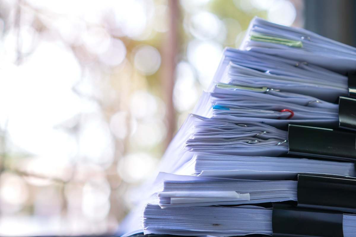 Destruction de documents obligations légales en France Documents d'affaires non classés sur un bureau avec stylo et trombones, concept de planification budgétaire.
