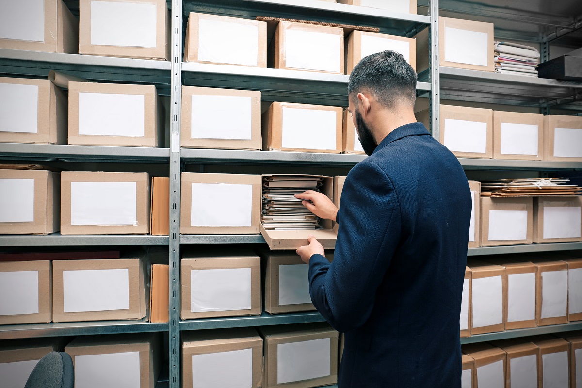 Les 4 étapes d’un processus de destruction d’archives ultra-sécurisé Un homme avec des documents d'archive