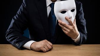 Homme en costume cravate avec un masque pour cacher son identité