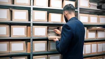 Les 4 étapes d’un processus de destruction d’archives ultra-sécurisé Un homme avec des documents d'archive